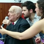 Yaco dando un discurso en el acto por el 70 Aniversario del Peretz. A sus costados, pasando algún saludo o alguna data olvidada, su nieto Ariel Korzin y Maira Visacovsky (exdirectora kinder Lanús).